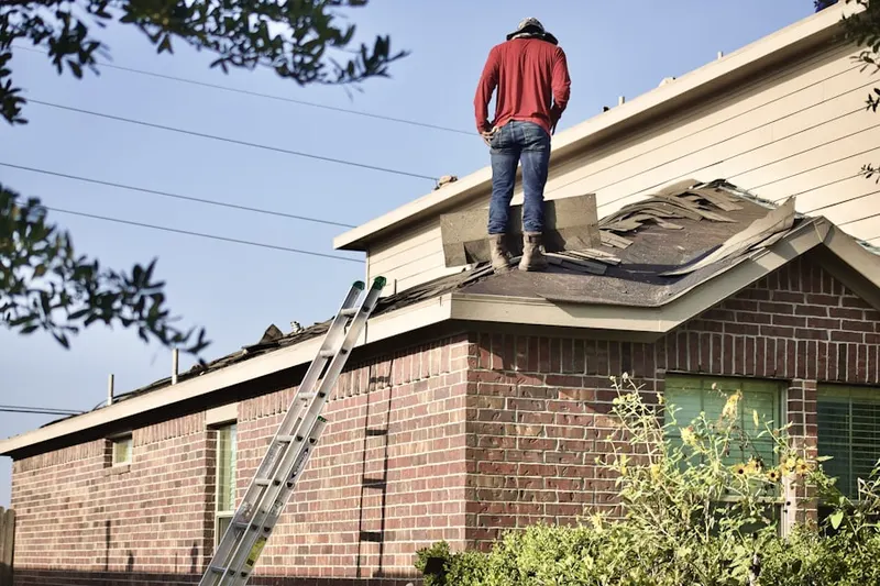 Professional roofer working on a residential roof in Drakes Landing